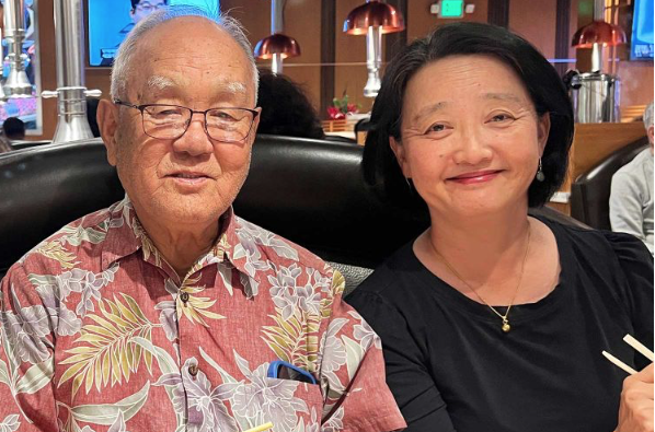 Photo of an elderly Korean man next to his daughter