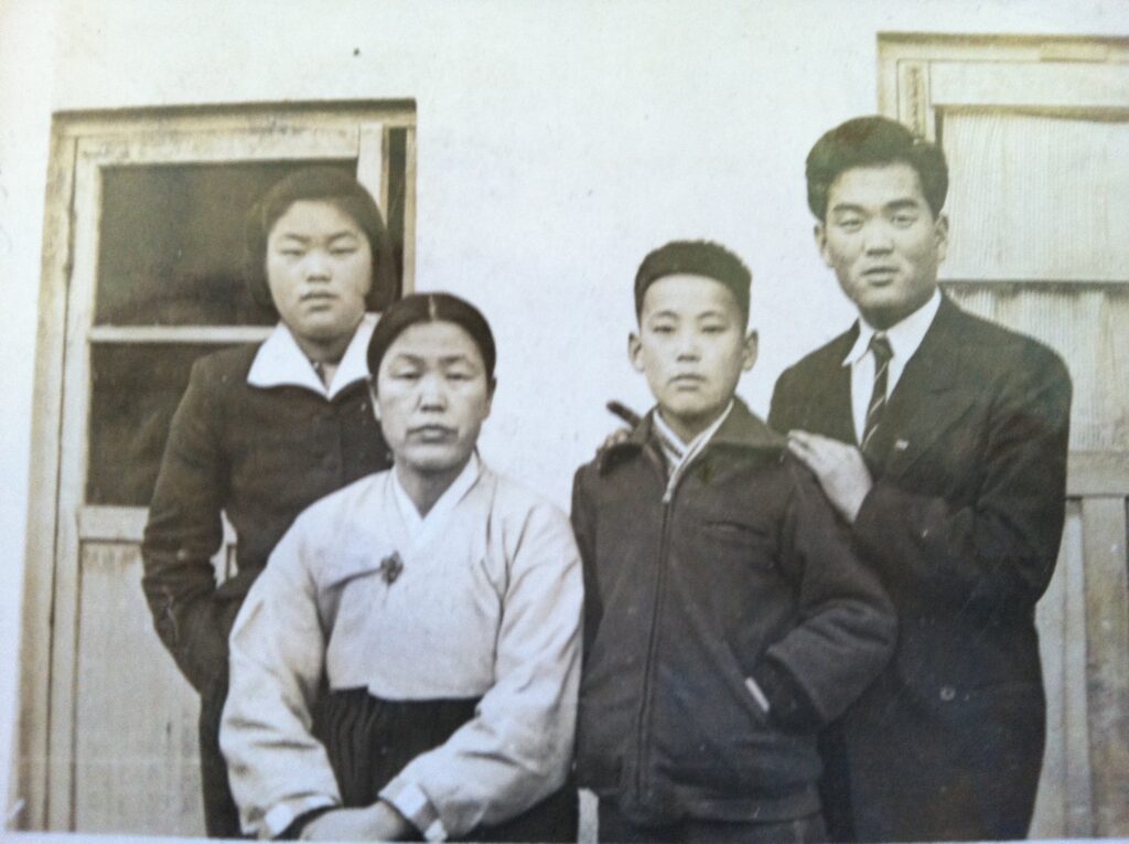 Black-and-white family photo: the author's father with his brother, sister, and mother